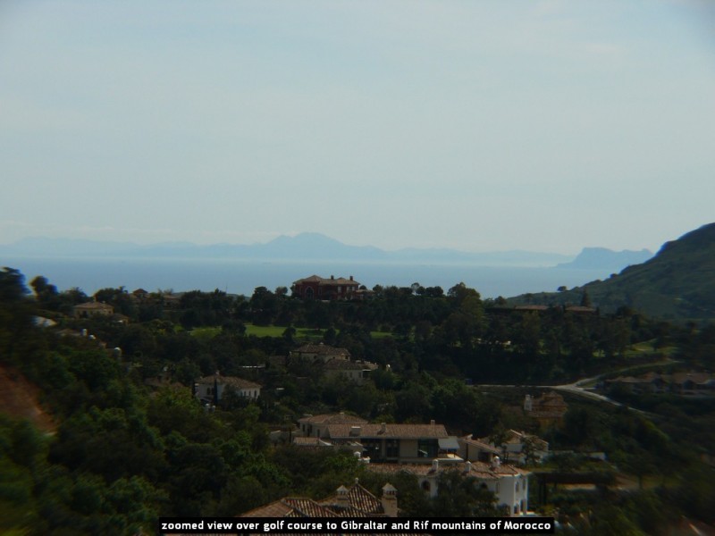 zoomed view over golf course to Gibraltar and Rif mountains of Morocco